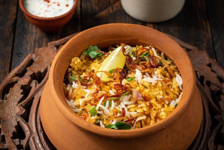 Veg Biryani: Aromatic rice layered with spiced vegetables, served with raita